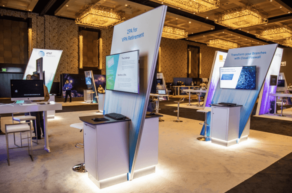 Custom sponsor kiosks JET built and installed in a hotel ballroom: printed graphic panels, mounted monitors, LED-lit bases, highboys and barstools